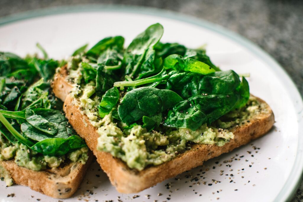 Close-up of a homemade avocado and spinach sandwich on whole grain toast  and Foods for Muscle Recovery