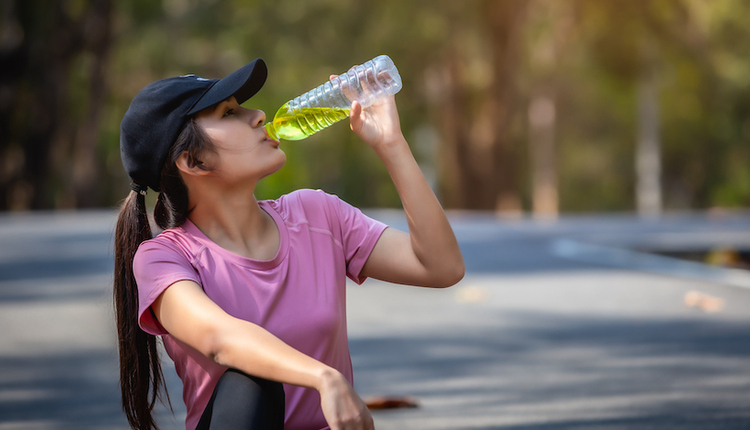 Young women resting and drinking water Hydration in Post-Workout Recovery.
