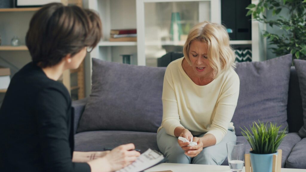 Two women sitting on a couch talking to each other about seasonal mental health affect