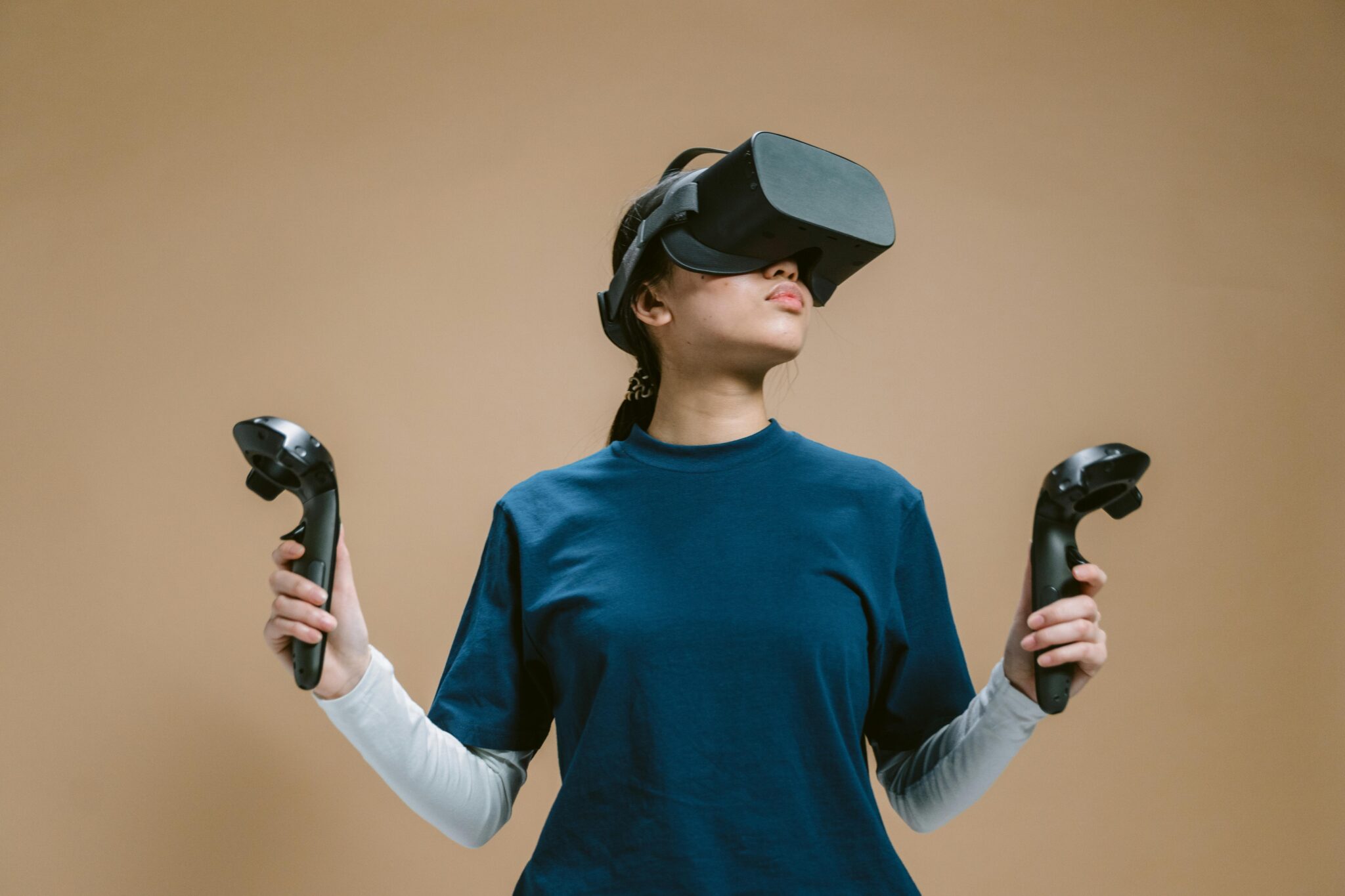 A young woman using a virtual reality headset and controllers, fully engaged in a sports session.