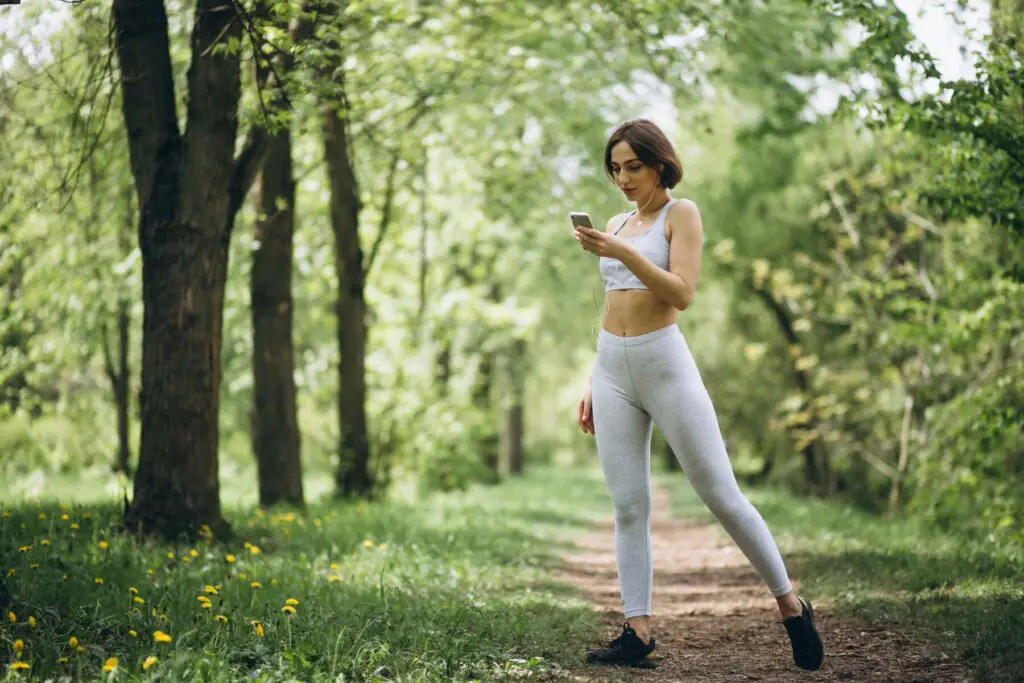 Woman in sport outdoor clothes Listening to Podcasts While Walking.