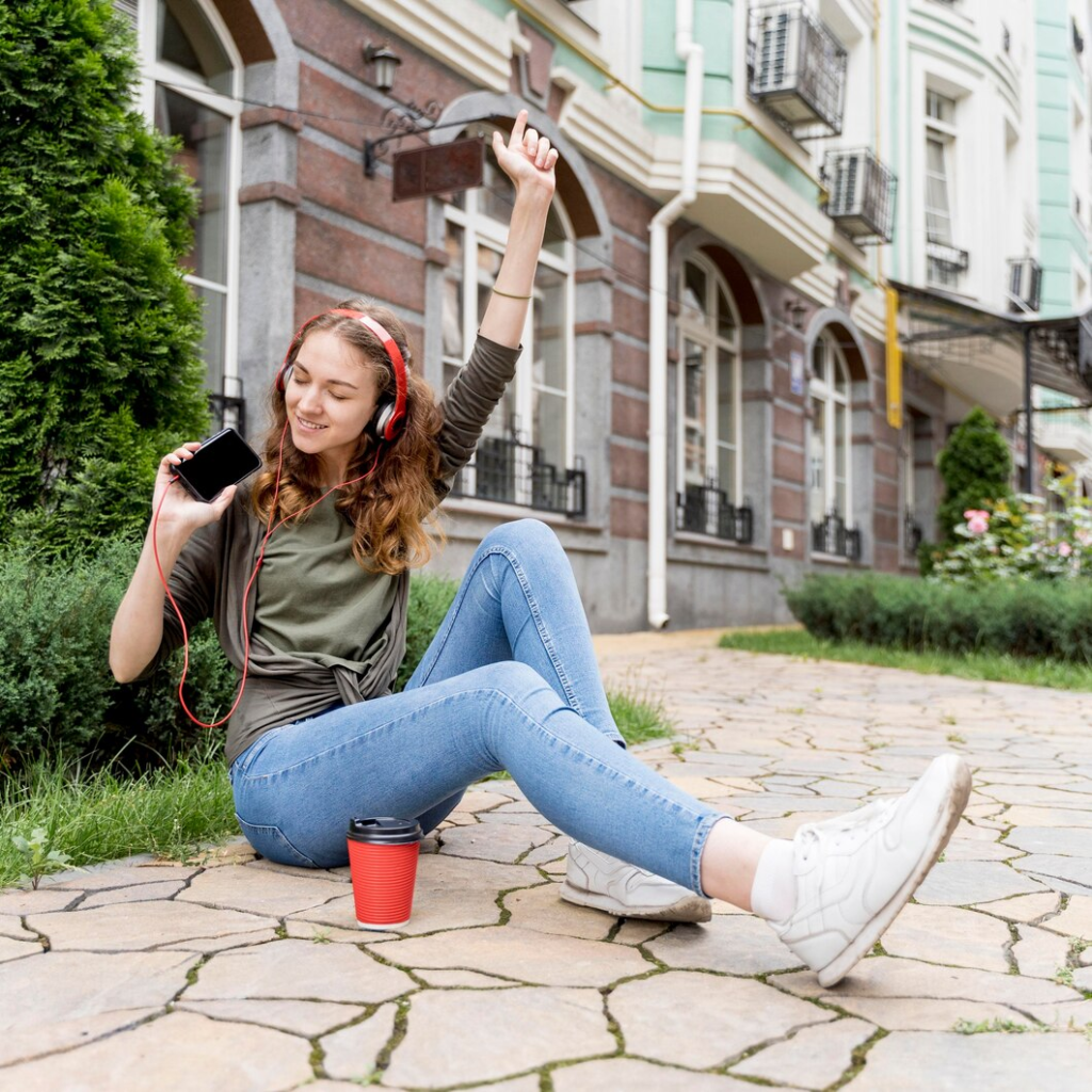 High angle young female listening to podcasts while walking session.