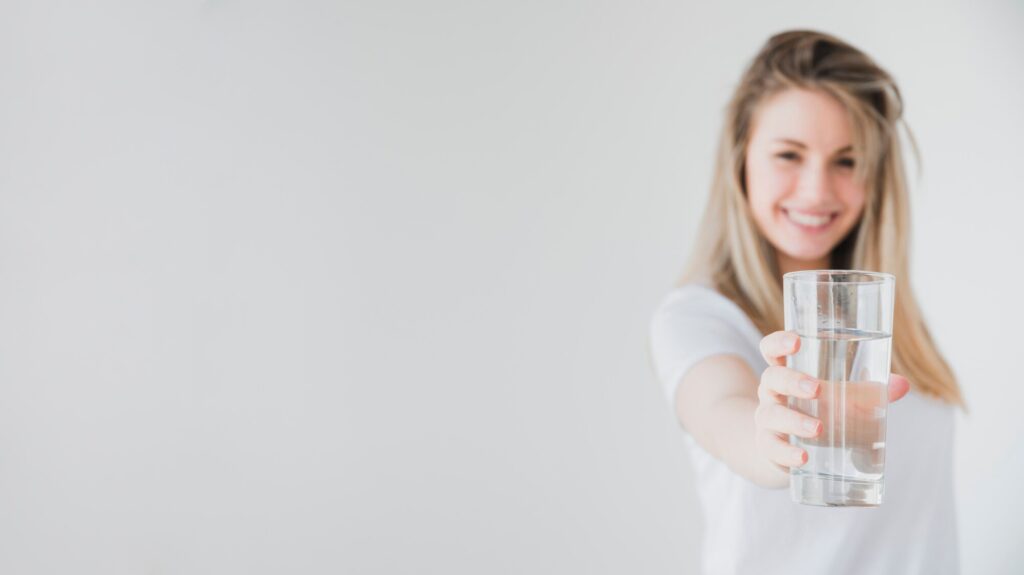 healthy girl holding alkaline glass water