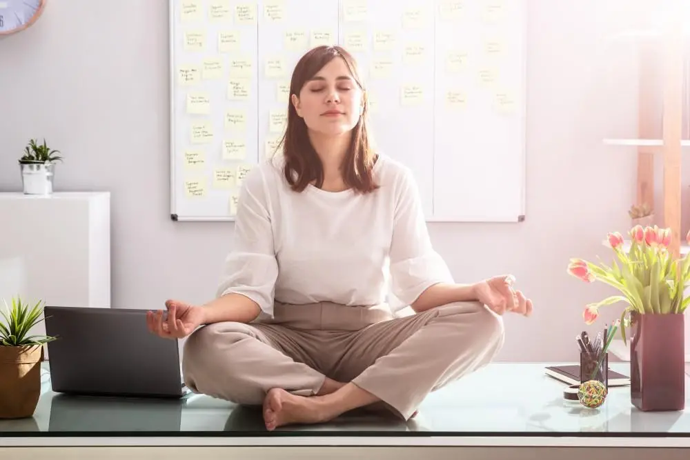 Woman performing desk yoga in the office.