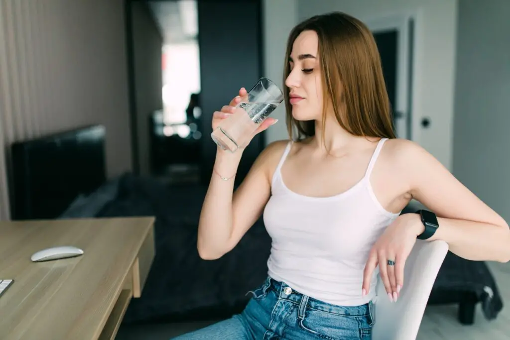 Young pretty woman drinking hydrogen-infused water.