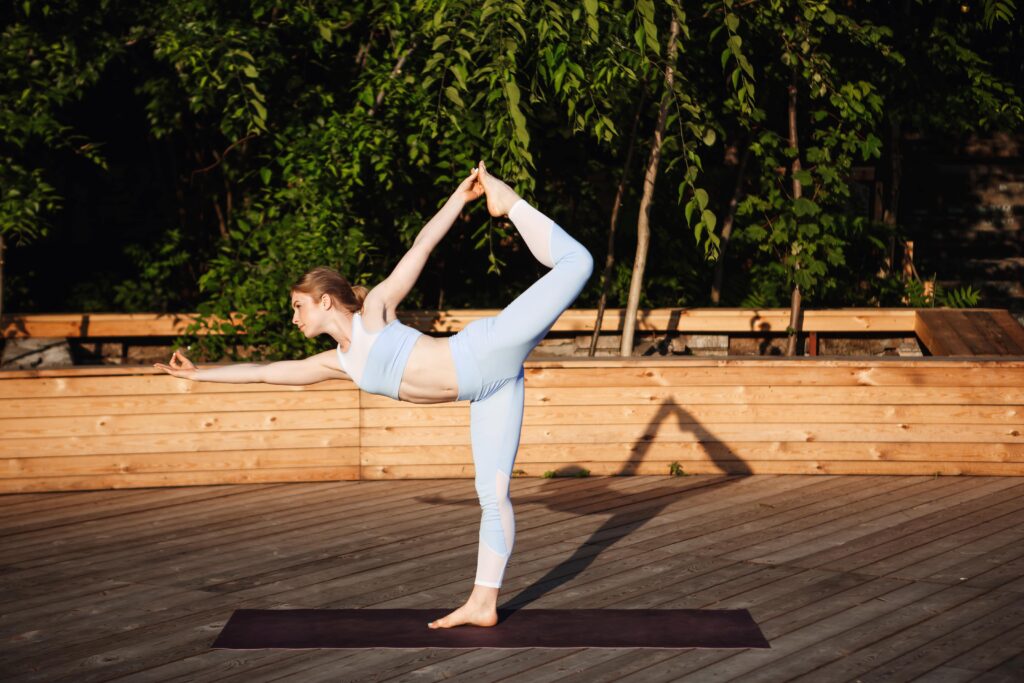 Young woman practicing yoga-Inspired stretching outdoors to improve balance, flexibility, and daily mobility